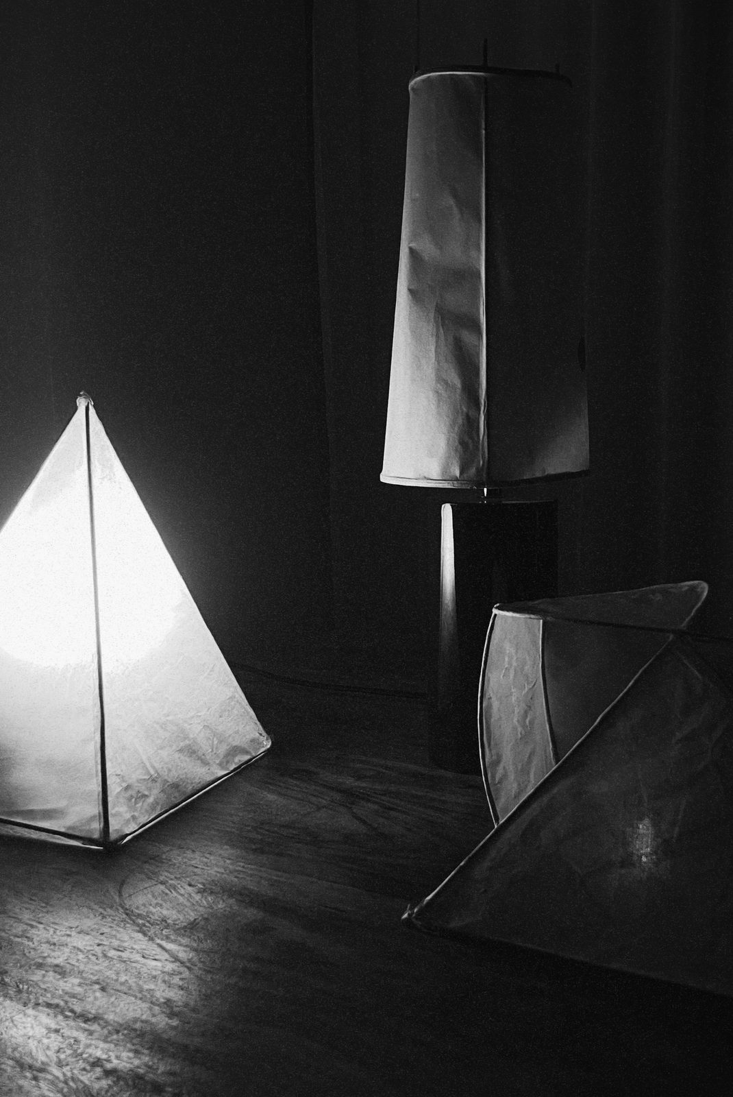 Drie papieren lampen in het donker, een piramide licht op